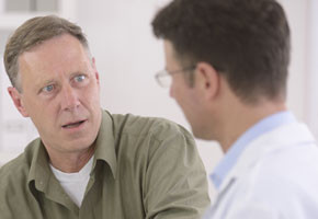 Doctor talking to mature male patient