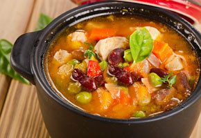 a crock filled with easy tuscan two bean soup on a wooden table